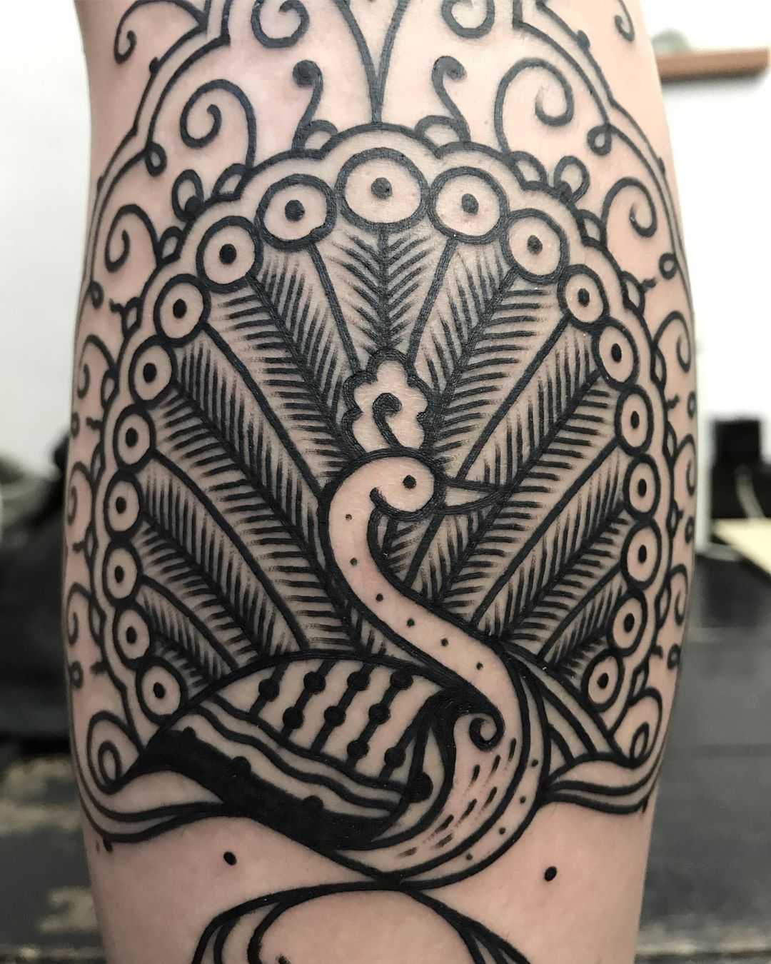 Peacock tattoo on the calf