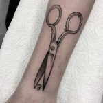 Scissors tattooed on the forearm