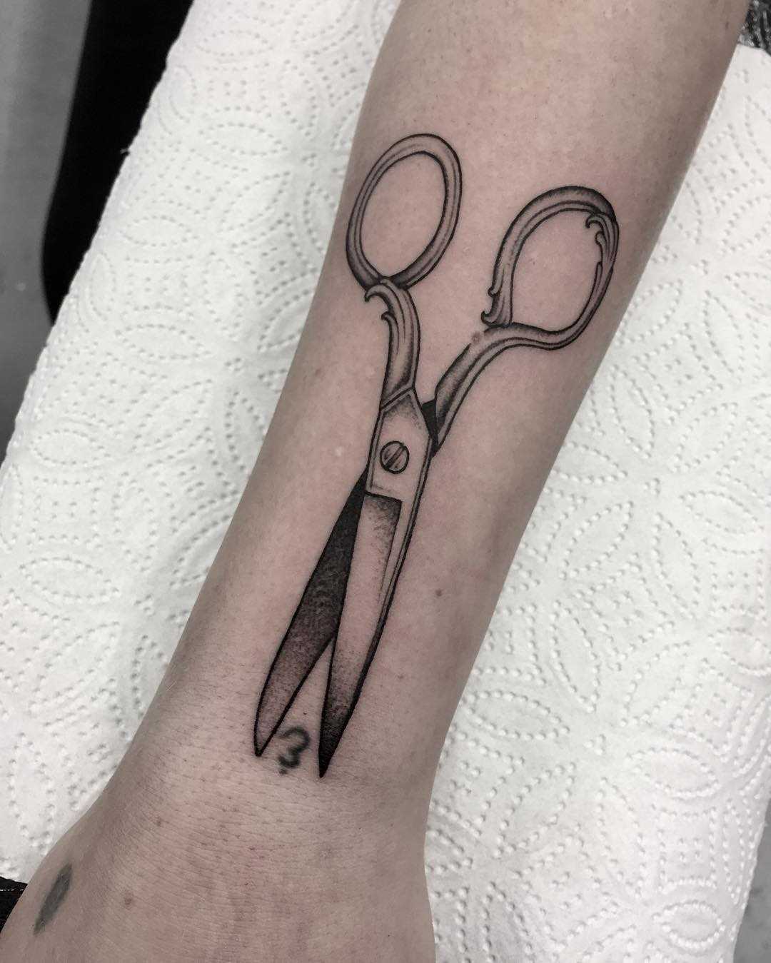 Scissors tattooed on the forearm