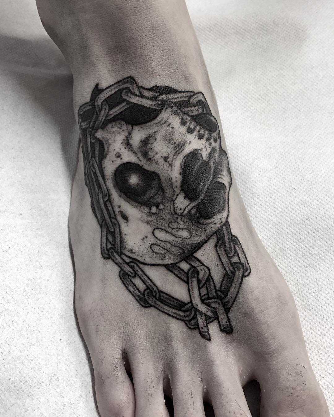 Skull and chain tattoo on the foot