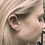 Spider web tattoo on the right ear