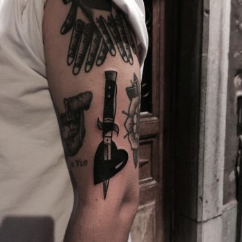 Switchblade and hear tattoo on the arm