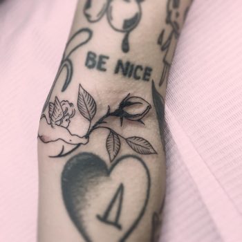 Tattoo of a cupid with a rose