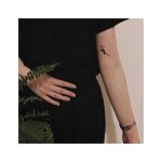 Tiny black floral piece on the arm