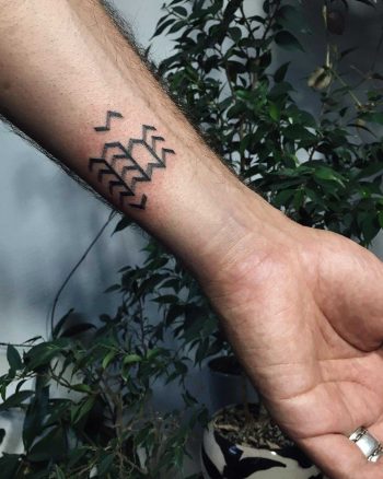 Tiny chevron pattern tattoo on the forearm