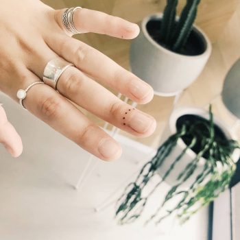 Tiny finger tattoo by artist Cholo