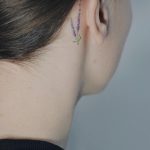 Tiny lavender tattoo behind the right ear