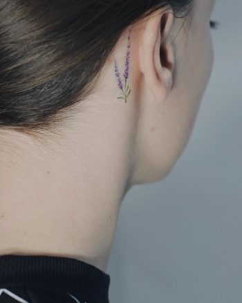 Tiny lavender tattoo behind the right ear