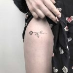 Tiny rose tattoo on the hip by Femme Fatale Tattoo