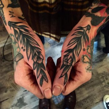 Traditional branches tattooed on thumbs