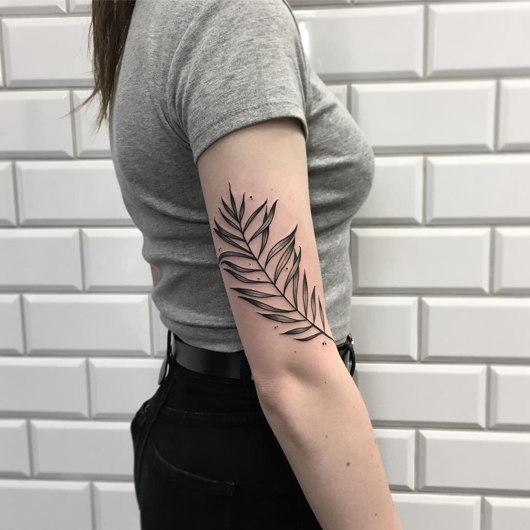 Tropical branch tattoo on the arm