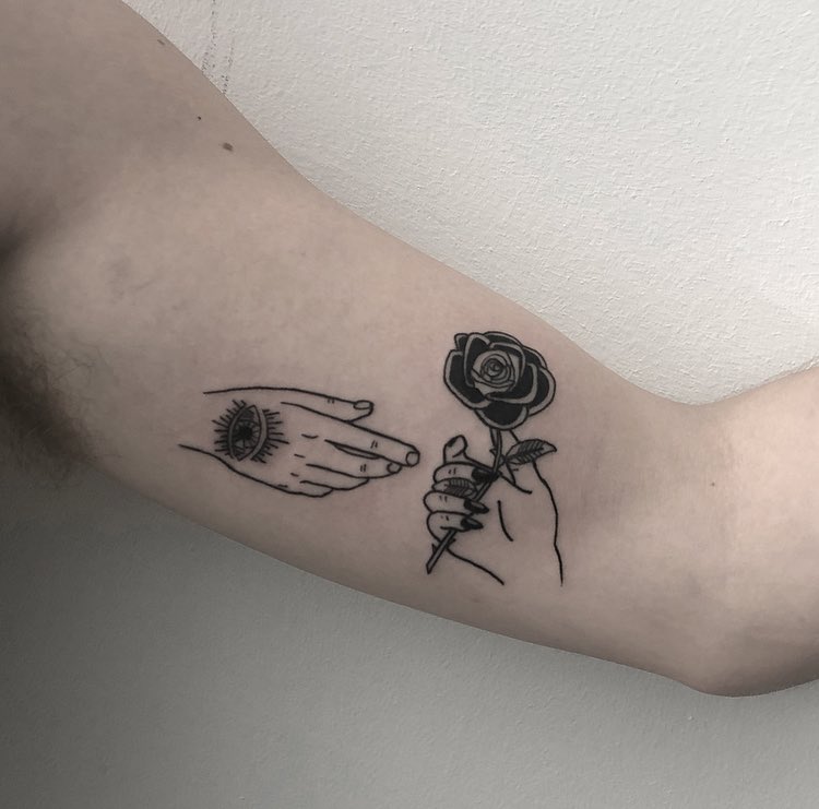 Two hands and a rose tattoo