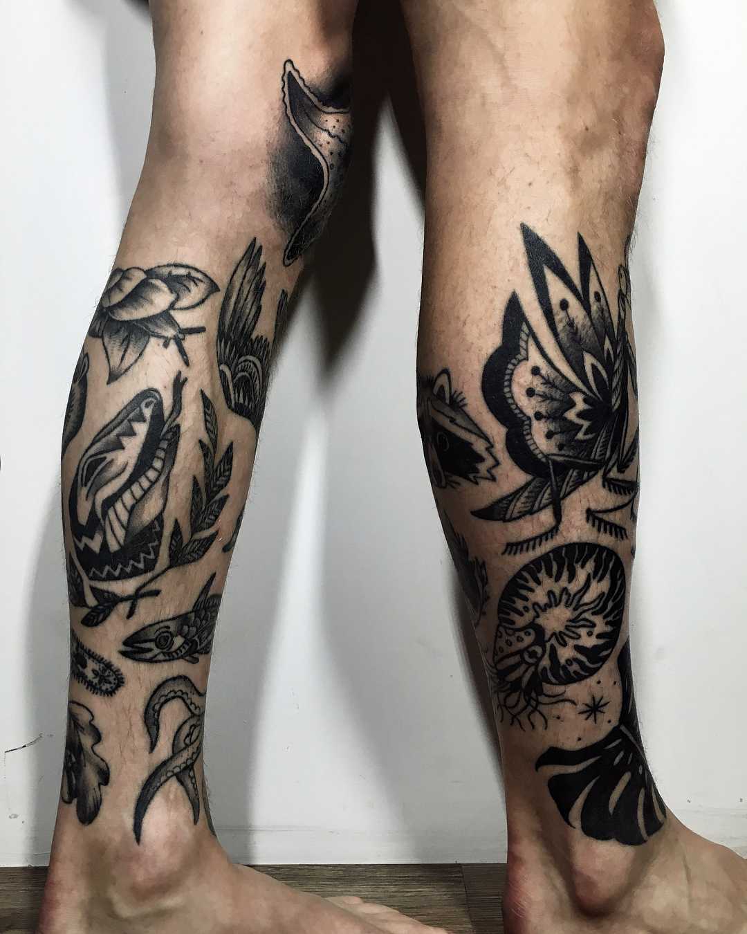 Various black tattoos on calves
