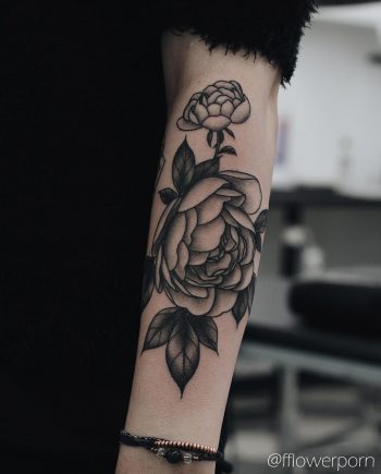 Black and grey peony tattoo on the forearm