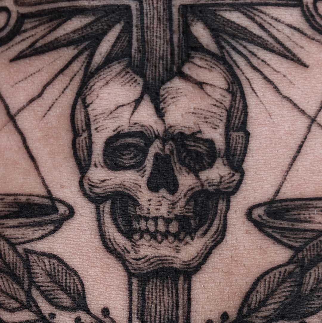 Cross pierced skull tattoo