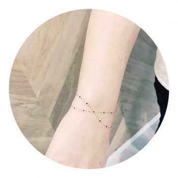 Delicate bracelet tattoo by Cholo