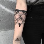 Negative space flower on the forearm