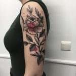 Red and black flower tattoo on the arm