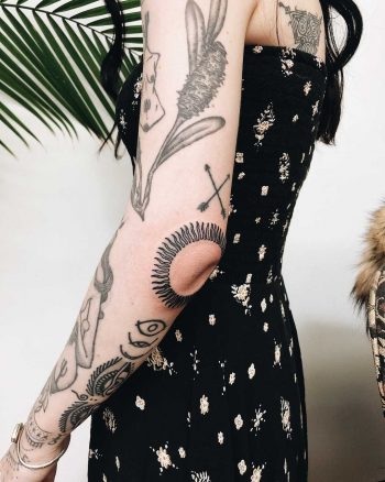 Sun tattoo over the left elbow