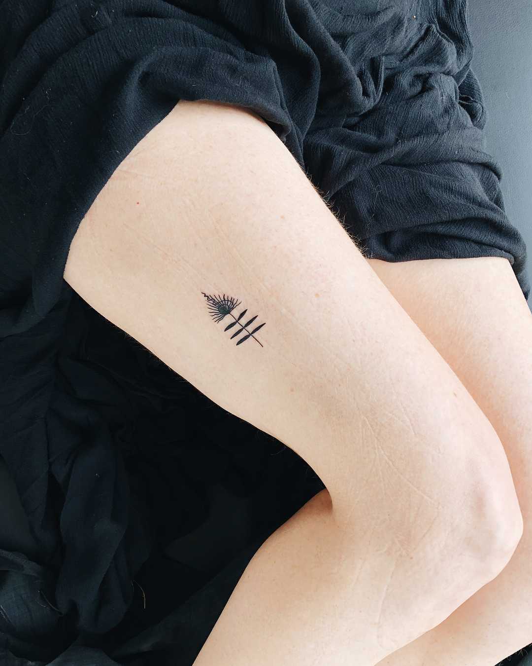 Tiny talisman tattoo on the thigh