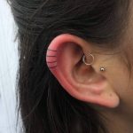 Triple line tattoo on the ear by Indy Voet