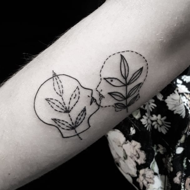 Two heads and branches tattoo