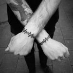 Barbed wire bracelet tattoos on both wrists