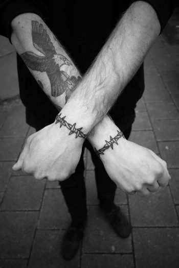 Barbed wire bracelet tattoos on both wrists