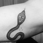 Black cobra tattoo on the bicep