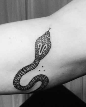 Black cobra tattoo on the bicep