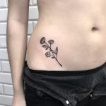 Black flower tattoo on the right hip