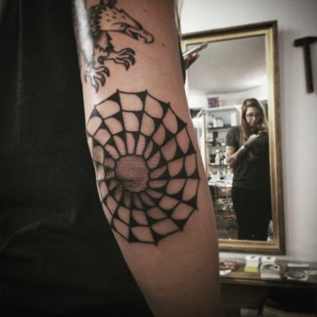 Black spider web elbow tattoo