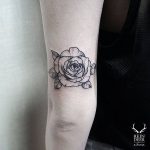 Blackwork style rose tattoo on the triceps