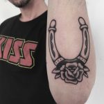 Horseshoe and rose tattoo on the forearm