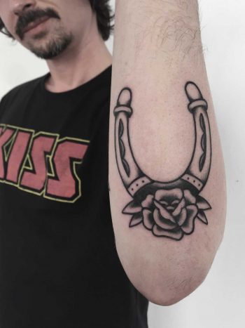 Horseshoe and rose tattoo on the forearm