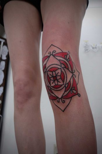 Red mandala tattoo on the knee