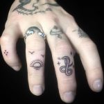 Sunset and snake finger tattoos