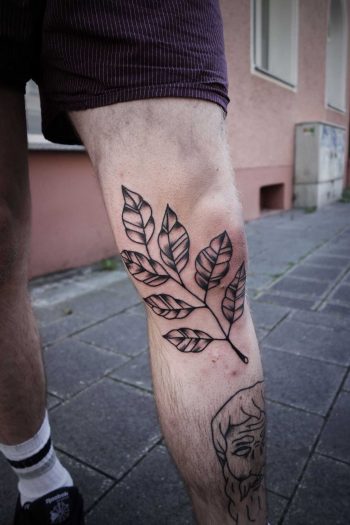 Black branch tattoo on the left leg