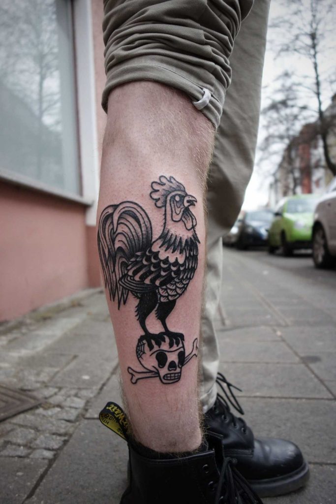 Black rooster on a skull tattoo