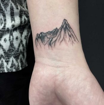 Blackwork mountain tattoo on the wrist