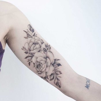 Grey rose tattoo on the arm