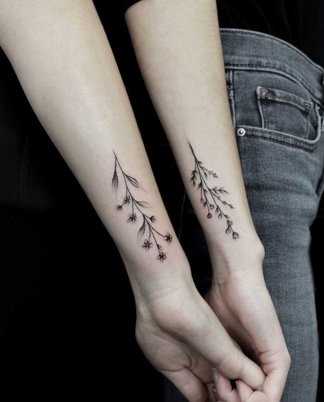 Matching flower tattoos on forearms 