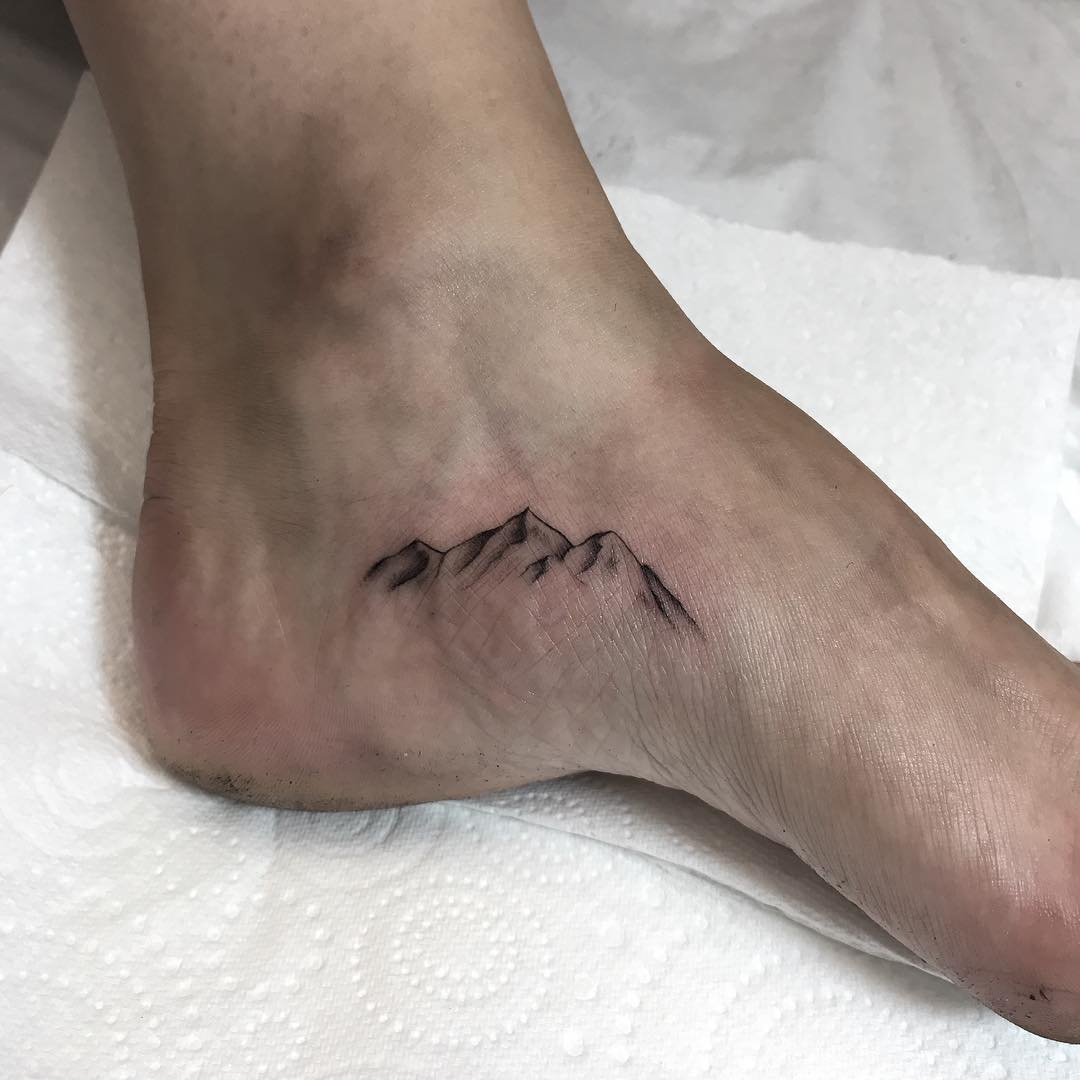 Mountains tattoo on a foot by Conz Thomas