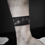 Negative space cosmic legband tattoo