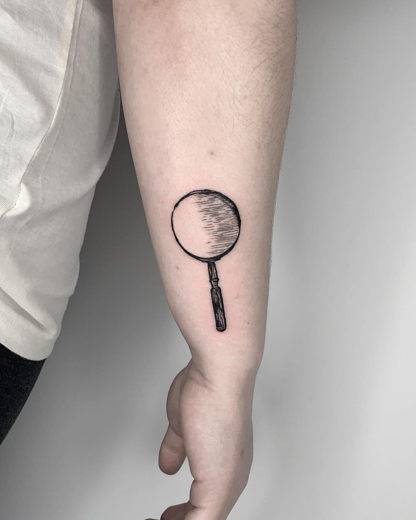 Sherlock Holme’s magnifying glass tattoo by Conz Thomas