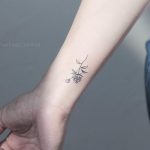 Small rose tattoo on the wrist by Rae Beat