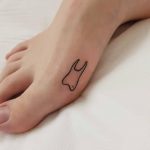Small tooth tattoo on a foot