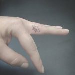 Tiny UFO tattoo on the middle finger