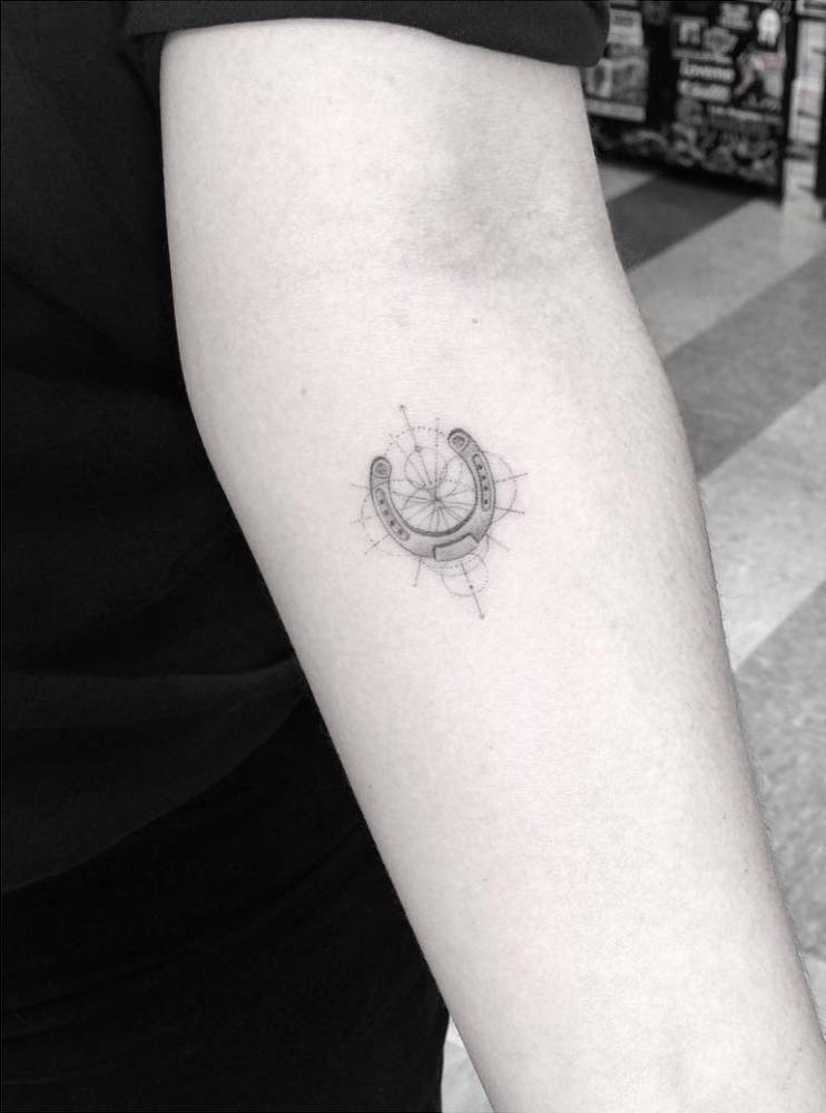 Tiny horseshoe tattoo on the forearm