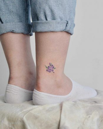 Violet flower tattoo on the ankle